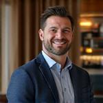 Marcus Sterling, Client Relations Manager for Luxury Gadgets, engaging with a client in a sophisticated setting.